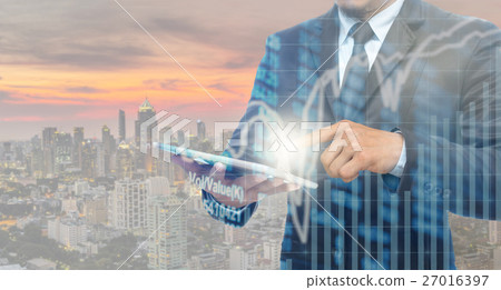 Double exposure of businessman using the tablet with Stock market chart on blurred building background, Business Trading concept Double exposure of businessman using the tablet with Stock market chart on blurred building background, Business Trading concept 27016397