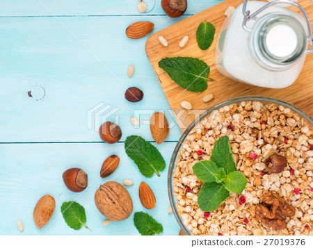 Muesli, milk and nuts on blue background 27019376