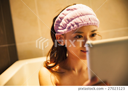 觀看片劑的婦女,當洗半浴時 觀看片劑的婦女,當洗半浴時 27023123
