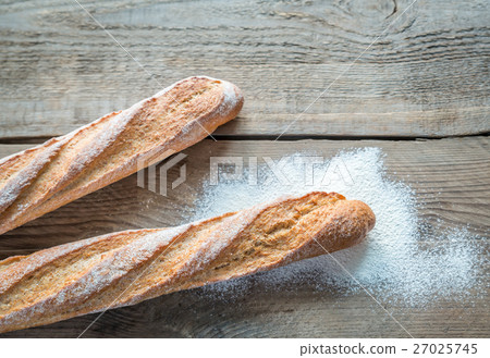 Two wholewheat baguettes on the wooden background 27025745