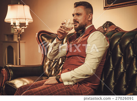 Extravagant stylish man with glass of whisky Extravagant stylish man with glass of whisky 27026091