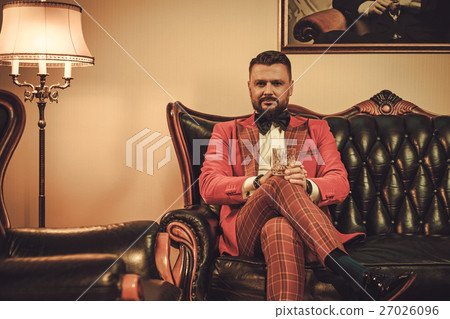Extravagant stylish man with glass of whisky Extravagant stylish man with glass of whisky 27026096