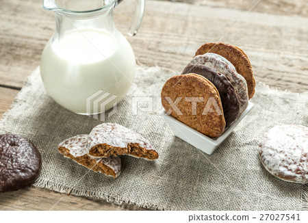Glazed gingerbread cakes with pitcher of milk 27027541