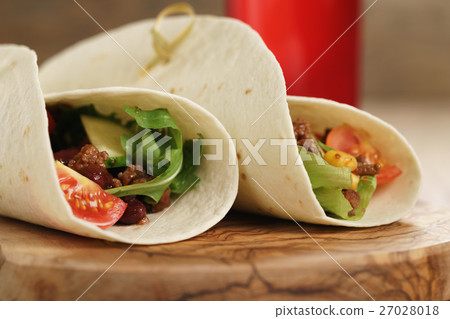 fresh homemade tortilla wrap sandwiches with beef and vegetables on olive board 27028018
