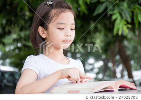 Little Asian child reading a book outdoor Little Asian child reading a book outdoor 27028708