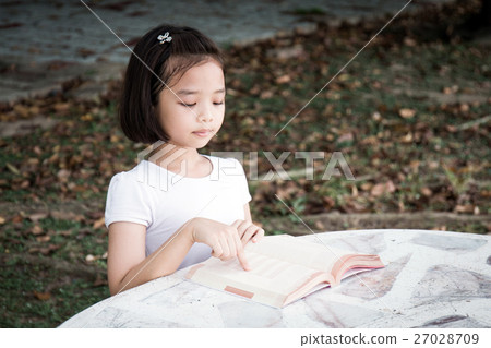 Little Asian child reading a book outdoor Little Asian child reading a book outdoor 27028709