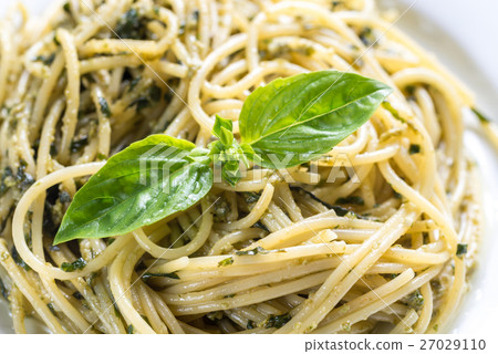 Portion of pasta with pesto sauce and basil leaf Portion of pasta with pesto sauce and basil leaf 27029110