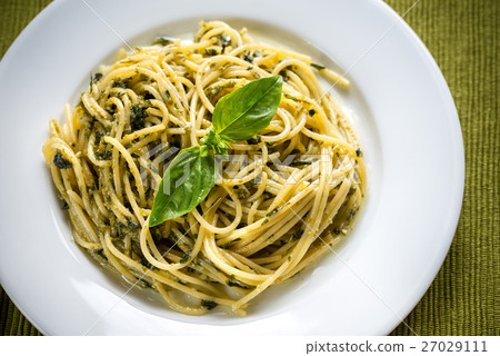 Portion of pasta with pesto sauce and basil leaf Portion of pasta with pesto sauce and basil leaf 27029111