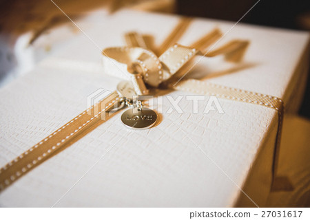 White present box decorated with golden ribbon 27031617