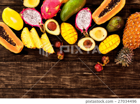 Tropical fruit on dark wooden background, top view 27034496