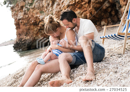 Family with son at the beach, enjoying time at 27034525