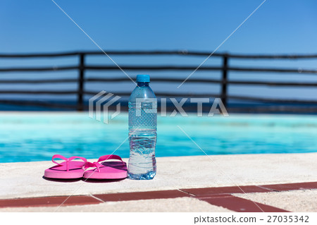 Plastic bottle with pure water and slippers  27035342