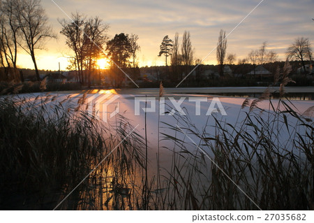 Winter sunset on the village pond. 27035682