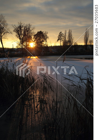 Winter sunset on the village pond. 27035683