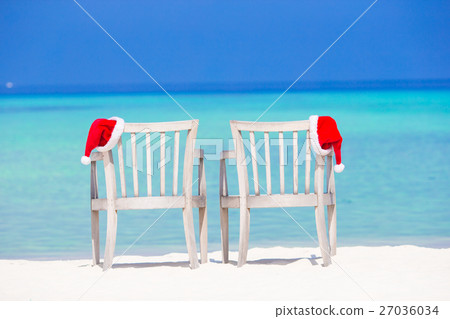 Closeup santa hat on chair on tropical white beach Closeup santa hat on chair on tropical white beach 27036034