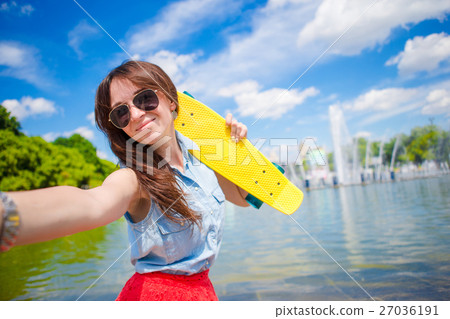 Young girl having fun with skateboard in the park Young girl having fun with skateboard in the park 27036191