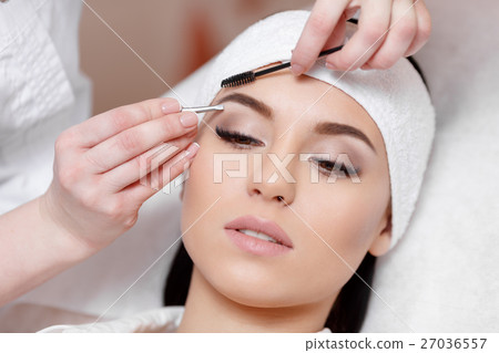 Beautiful young woman gets eyebrow correction 27036557