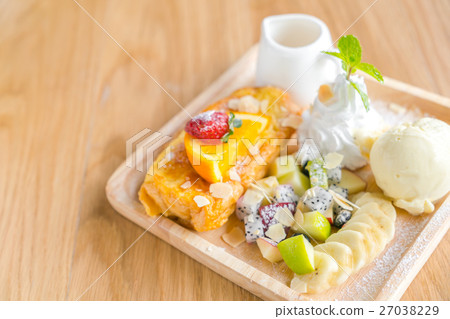 French toast with powdered sugar and a strawberry on wood table . 27038229