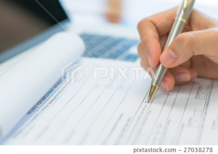 Hand with pen over application form . 27038278