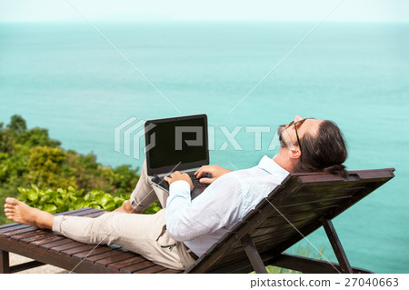 Businessman wearing a suit using laptop on the 27040663