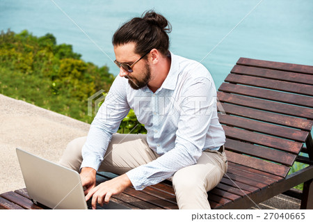 Businessman wearing a suit using laptop on the 27040665