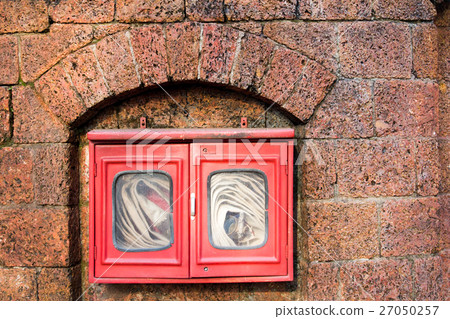 Fire hose in red box on brick wall background Fire hose in red box on brick wall background 27050257