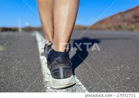 young man walking by the center line of a road young man walking by the center line of a road 27052711
