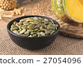 Green pumpkin seeds peeled in a black cup 27054096