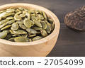 Close-up green pumpkin seeds in a wooden cup 27054099