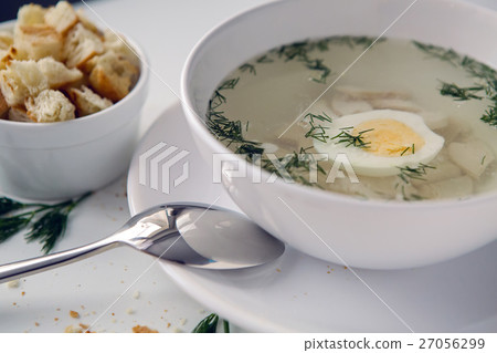 chicken soup in a white plate with bowl pieces 27056299