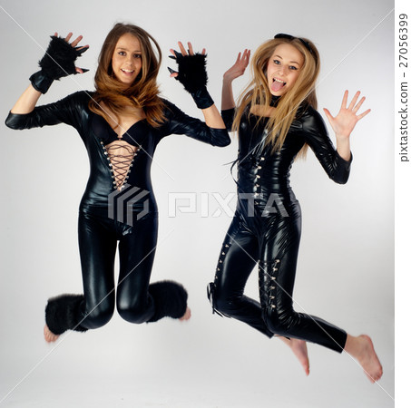 Two pretty girls in cat costumes jumping 27056399