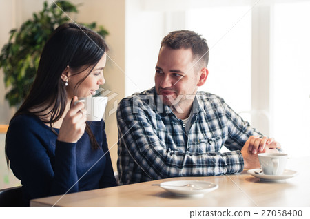 Happy couple talking at cafe, drinking tea Happy couple talking at cafe, drinking tea 27058400