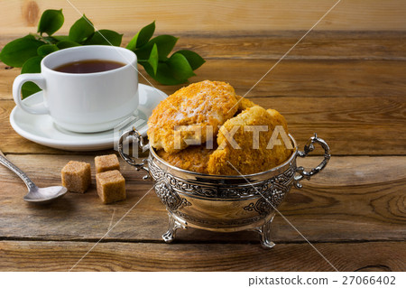 Homemade biscuits in metal vase and cup of tea Homemade biscuits in metal vase and cup of tea 27066402