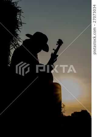A young man playing the banjo The straw in the fie A young man playing the banjo The straw in the fie 27073034