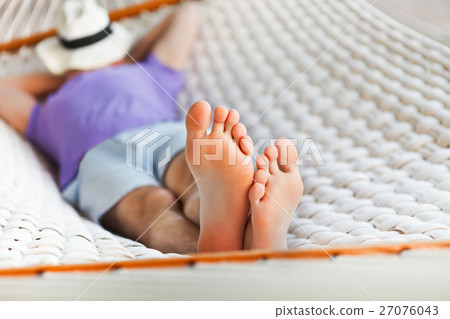 Man in hat in a hammock on a summer day 27076043