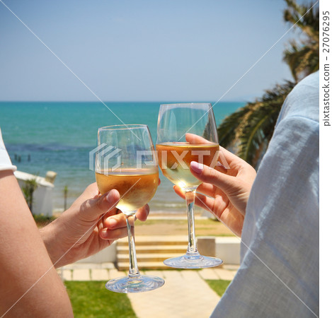 Man and woman clanging wine glasses with wine Man and woman clanging wine glasses with wine 27076295