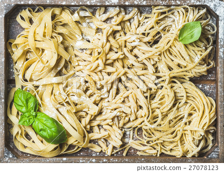 Uncooked Italian pasta in wooden tray with basil Uncooked Italian pasta in wooden tray with basil 27078123