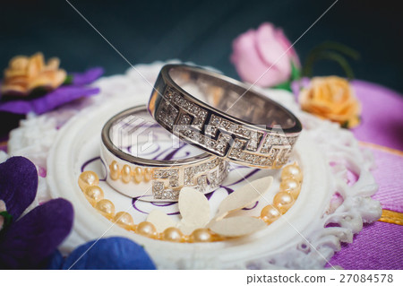 Wedding rings on purple pillow, selective focus Wedding rings on purple pillow, selective focus 27084578
