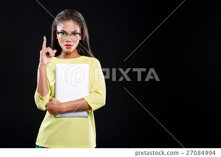 Serious girl is holding a laptop 27084994