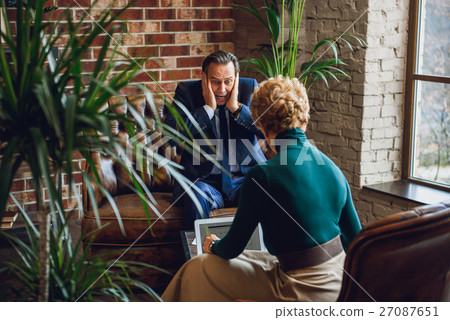 Horrified mature businessman in office of 27087651