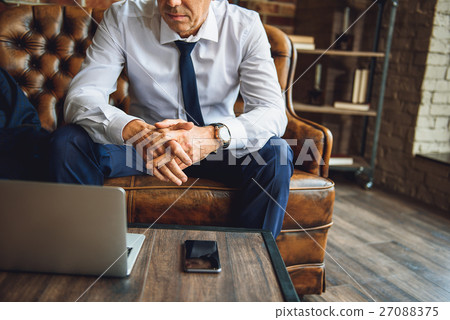 Man sitting on couch afore laptop and mobile 27088375