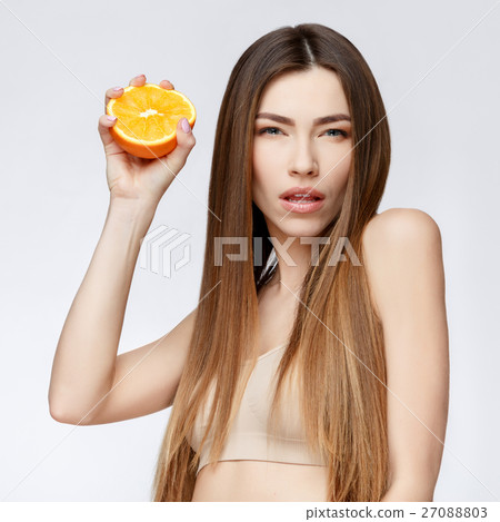 Beautiful Woman with Clean Fresh Skin holding 27088803