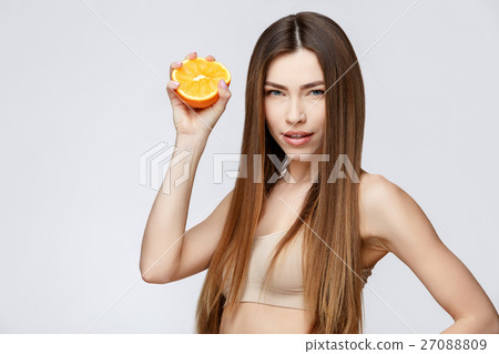 Beautiful Woman with Clean Fresh Skin holding 27088809