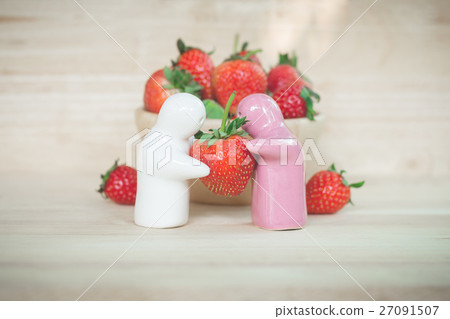 Ceramic toy giving a strawberry to couple for love Ceramic toy giving a strawberry to couple for love 27091507