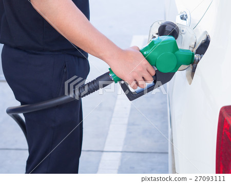 man handle fuel nozzle to refuel. in gas station. man handle fuel nozzle to refuel. in gas station. 27093111