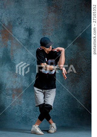 Young man break dancing on wall background. 27105352
