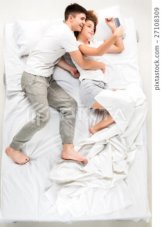The young lovely couple lying in a bed 27108309