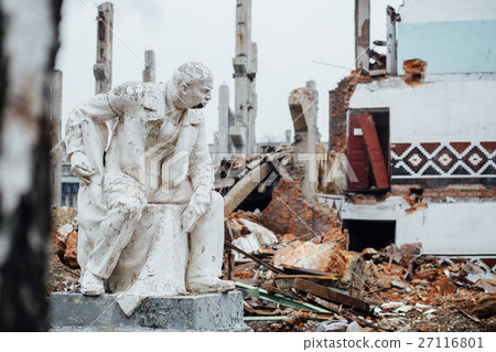 Damaged Lenin statue sitting on a chair with  book 27116801