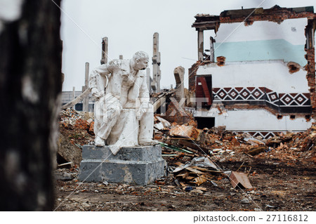 Damaged Lenin statue sitting on a chair with  book 27116812