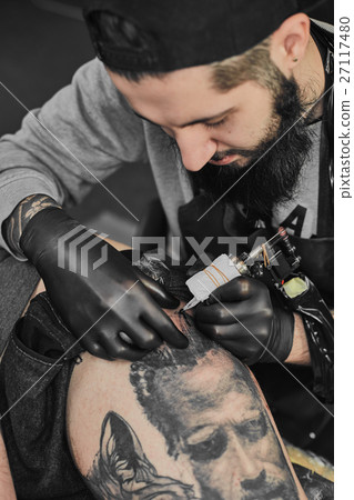Tattoo master is tattooing in the tattoosalon Tattoo master is tattooing in the tattoosalon 27117480